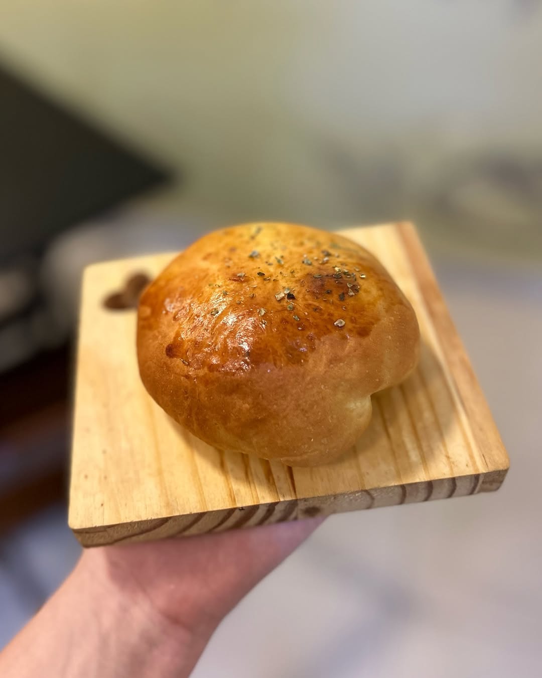 Pão de batata recheado artesanal do Gastropão sobre tábua de madeira